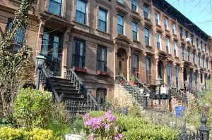 Houses of red brick in a row with gardens